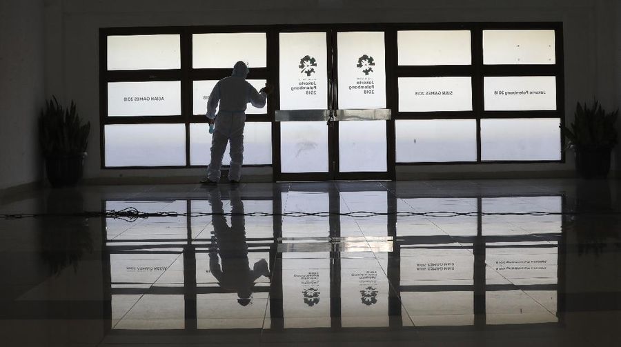 A health worker walks inside a quarantine facility for people showing symptoms of the COVID-19 amid the coronavirus outbreak at Patriot Candrabhaga stadium in Bekasi on the outskirts of Jakarta, Indonesia, Tuesday, Sept. 22, 2020.(AP Photo/Achmad Ibrahim)