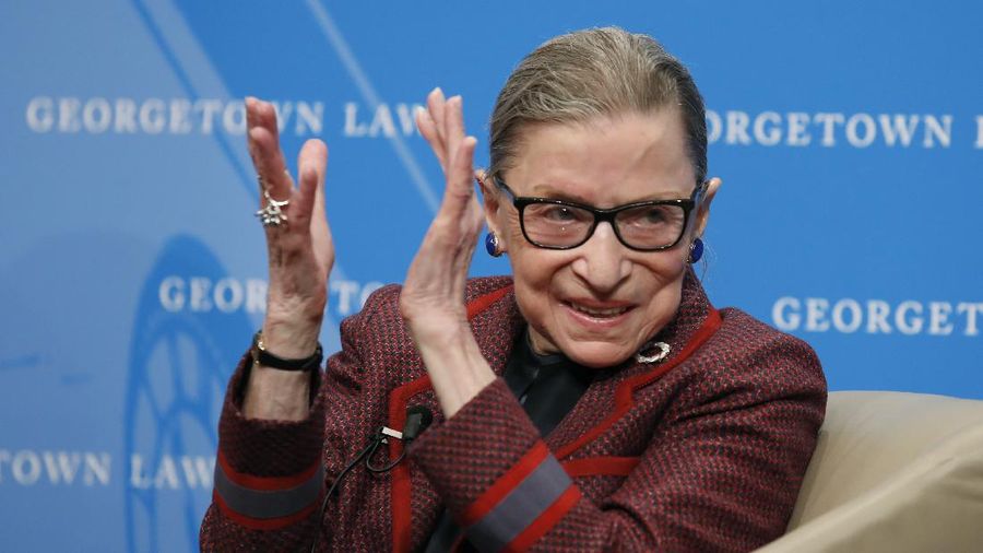 FILE - In this April 6, 2018, file photo, Supreme Court Justice Ruth Bader Ginsburg applauds after a performance in her honor after she spoke about her life and work during a discussion at Georgetown Law School in Washington. The Supreme Court says Ginsburg has died of metastatic pancreatic cancer at age 87. (AP Photo/Alex Brandon, File)