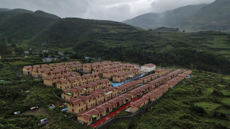 A Yi ethnic minority member stands inside his house displaying posters of Chinese President Xi Jinping and his wife Peng Liyuan, in Xujiashan village in Ganluo County, southwest China's Sichuan province, on Sept. 10, 2020. Communist Party Xi’s smiling visage looks down from the walls of virtually every home inhabited by members of the Yi minority group in a remote corner of China’s Sichuan province. Xi has replaced former leader Mao Zedong for pride of place in new brick and concrete homes built to replace crumbling traditional structures in Sichuan’s Liangshan Yi Autonomous Prefecture, which his home to about 2 million members of the group. (AP Photo/Andy Wong)