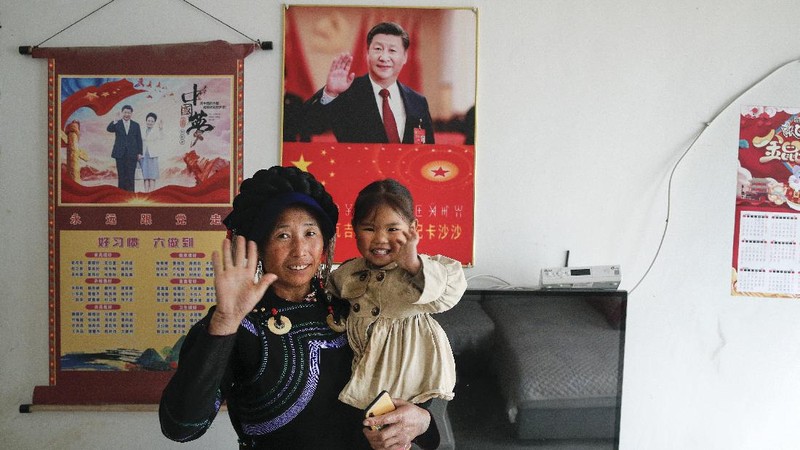 A Yi ethnic minority member stands inside his house displaying posters of Chinese President Xi Jinping and his wife Peng Liyuan, in Xujiashan village in Ganluo County, southwest China's Sichuan province, on Sept. 10, 2020. Communist Party Xi’s smiling visage looks down from the walls of virtually every home inhabited by members of the Yi minority group in a remote corner of China’s Sichuan province. Xi has replaced former leader Mao Zedong for pride of place in new brick and concrete homes built to replace crumbling traditional structures in Sichuan’s Liangshan Yi Autonomous Prefecture, which his home to about 2 million members of the group. (AP Photo/Andy Wong)