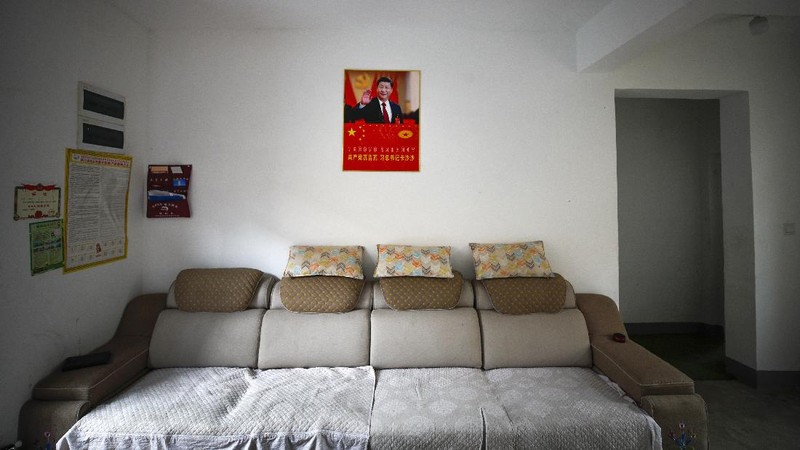 A Yi ethnic minority member stands inside his house displaying posters of Chinese President Xi Jinping and his wife Peng Liyuan, in Xujiashan village in Ganluo County, southwest China's Sichuan province, on Sept. 10, 2020. Communist Party Xi’s smiling visage looks down from the walls of virtually every home inhabited by members of the Yi minority group in a remote corner of China’s Sichuan province. Xi has replaced former leader Mao Zedong for pride of place in new brick and concrete homes built to replace crumbling traditional structures in Sichuan’s Liangshan Yi Autonomous Prefecture, which his home to about 2 million members of the group. (AP Photo/Andy Wong)