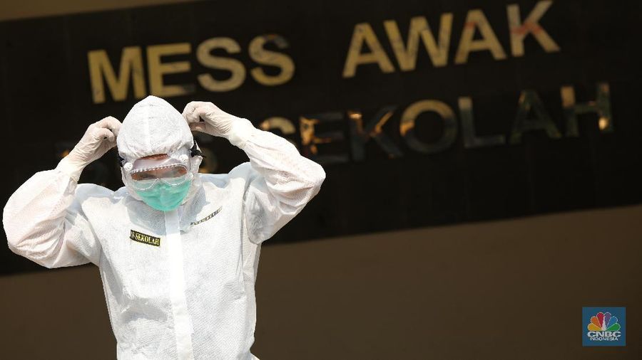 Petugas melakukan penguapan dengan liquid disinfektan ke bus sekolah yang digunakan untuk mengevakuasi pasien Covid-19 berstatus OTG (Orang Tanpa Gejala) di Posko Gabungan PSBB dan Gakplin Protkes, Kramat Jati, Jakarta Timur. (CNBC Indonesia/Andrean Kristianto)