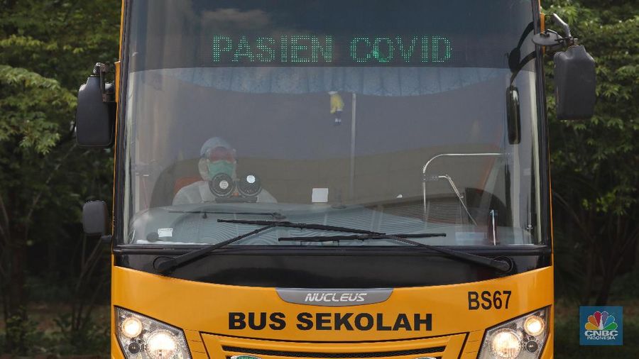 Petugas melakukan penguapan dengan liquid disinfektan ke bus sekolah yang digunakan untuk mengevakuasi pasien Covid-19 berstatus OTG (Orang Tanpa Gejala) di Posko Gabungan PSBB dan Gakplin Protkes, Kramat Jati, Jakarta Timur. (CNBC Indonesia/Andrean Kristianto)