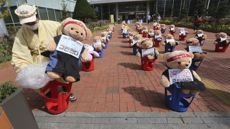 Street vendors sit to protest against a crackdown on illegal street vendors, in front of the Mapo ward office in Seoul, South Korea, Thursday, Sept. 24, 2020. They replaced protestors with teddy bears to avoid the violation of an ongoing ban on rallies with more than 10 people amid the coronavirus pandemic. The signs read: 