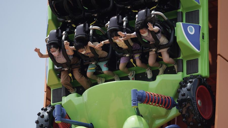 Visitors wearing face masks line up to take photos with the iconic cartoon characters Donald Duck and Daisy Duck at the Hong Kong Disneyland, Friday, Sept. 25, 2020. Hong Kong Disneyland reopened its doors to visitors after closed temporarily due to the coronavirus outbreak. (AP Photo/Kin Cheung)