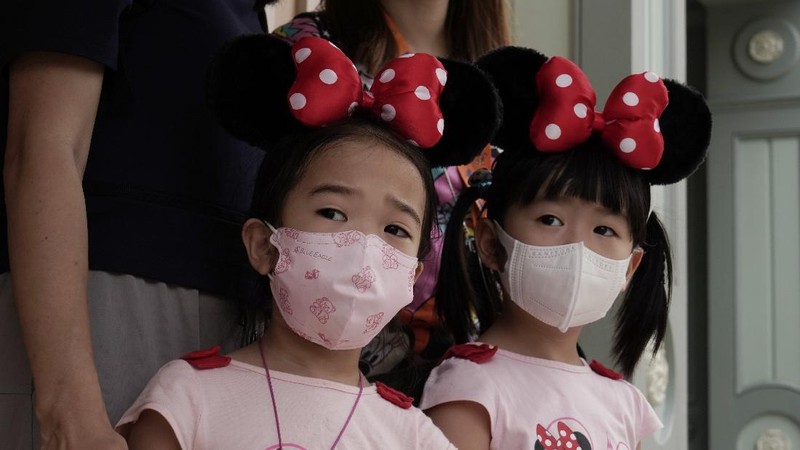 Visitors wearing face masks line up to take photos with the iconic cartoon characters Donald Duck and Daisy Duck at the Hong Kong Disneyland, Friday, Sept. 25, 2020. Hong Kong Disneyland reopened its doors to visitors after closed temporarily due to the coronavirus outbreak. (AP Photo/Kin Cheung)