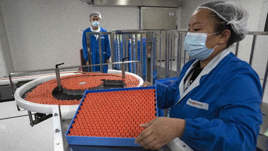 A worker inspects vials of SARS CoV-2 Vaccine for COVID-19 produced by SinoVac at its factory in Beijing on Thursday, Sept. 24, 2020. A Chinese health official said Friday, Sept. 25, 2020, that the country's annual production capacity for coronavirus vaccines will top 1 billion doses next year, following an aggressive government support program for construction of new factories. (AP Photo/Ng Han Guan)