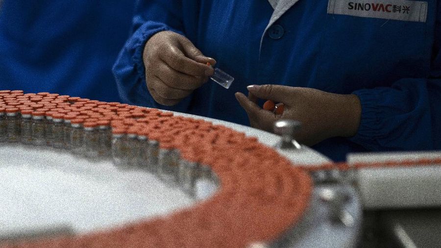 A worker inspects vials of SARS CoV-2 Vaccine for COVID-19 produced by SinoVac at its factory in Beijing on Thursday, Sept. 24, 2020. A Chinese health official said Friday, Sept. 25, 2020, that the country's annual production capacity for coronavirus vaccines will top 1 billion doses next year, following an aggressive government support program for construction of new factories. (AP Photo/Ng Han Guan)