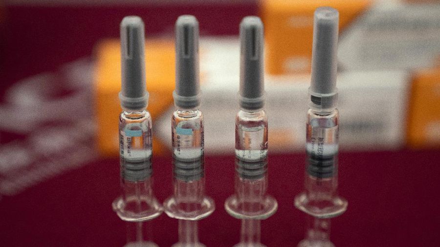 A worker inspects vials of SARS CoV-2 Vaccine for COVID-19 produced by SinoVac at its factory in Beijing on Thursday, Sept. 24, 2020. A Chinese health official said Friday, Sept. 25, 2020, that the country's annual production capacity for coronavirus vaccines will top 1 billion doses next year, following an aggressive government support program for construction of new factories. (AP Photo/Ng Han Guan)
