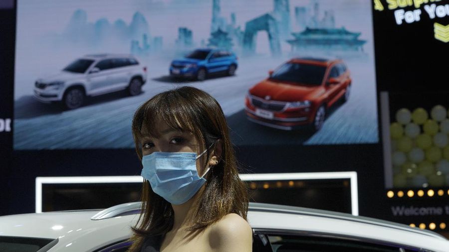 A car model wears a mask to protect from coronavirus, during the Auto China 2020 show in Beijing on Saturday, Sept. 26, 2020. Ford, Nissan and BMW unveiled electric models with more range for China on Saturday as the Beijing auto show opened under anti-virus controls that included holding news conferences by international video link. (AP Photo/Ng Han Guan)