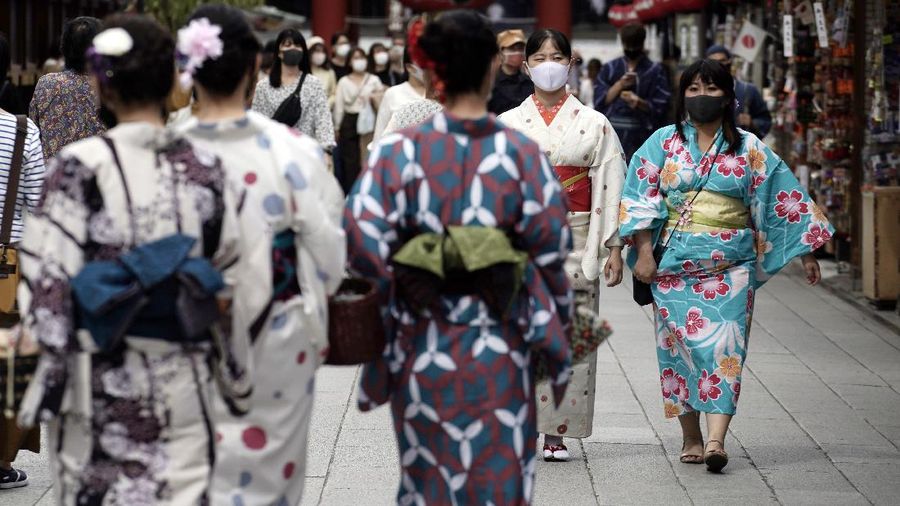 People wearing protective masks to help curb the spread of the coronavirus walk at shopping arcade at Asakusa district Tuesday, Sept. 29, 2020, in Tokyo. The Japanese capital confirmed more than 200 coronavirus cases on Tuesday. (AP Photo/Eugene Hoshiko)
