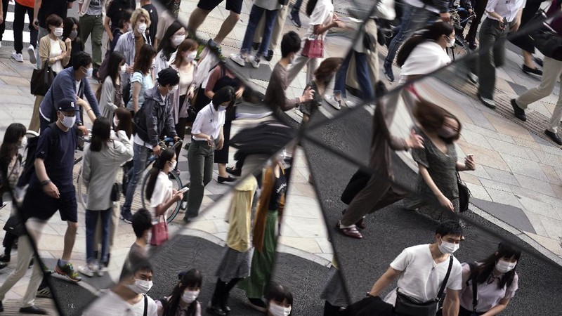 People wearing protective masks to help curb the spread of the coronavirus walk at shopping arcade at Asakusa district Tuesday, Sept. 29, 2020, in Tokyo. The Japanese capital confirmed more than 200 coronavirus cases on Tuesday. (AP Photo/Eugene Hoshiko)