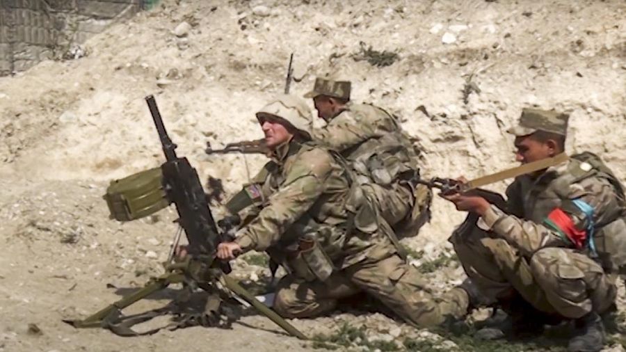 In this image taken from footage released by Azerbaijan's Defense Ministry on Sunday, Sept. 27, 2020, Azerbaijan's soldiers fire from a mortar at the contact line of the self-proclaimed Republic of Nagorno-Karabakh, Azerbaijan. Fighting between Armenian and Azerbaijani forces over the disputed separatist region of Nagorno-Karabakh continued on Monday morning after erupting the day before, with both sides blaming each other for resuming the attacks. (Azerbaijan's Defense Ministry via AP)