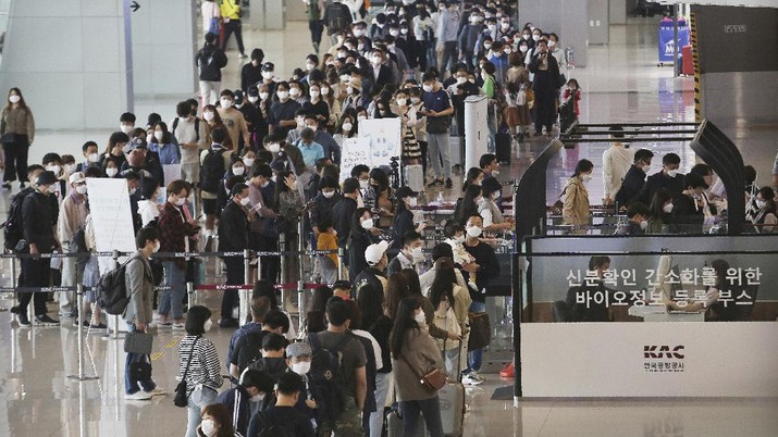 Passengers wearing face masks to help protect against the spread of the coronavirus line up to board planes ahead of the upcoming Chuseok holiday, the Korean version of Thanksgiving Day, at the domestic flight terminal of Gimpo airport in Seoul, South Korea, Wednesday, Sept. 30, 2020. (AP Photo/Ahn Young-joon)