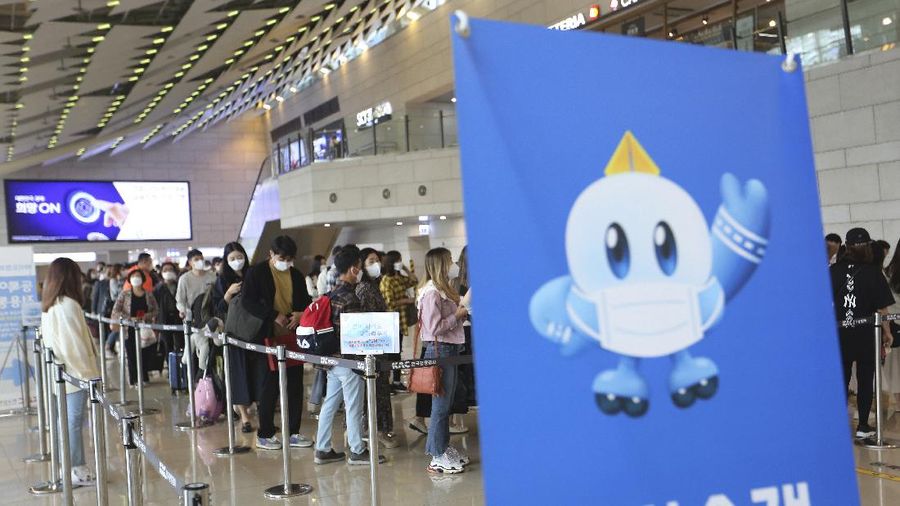 Passengers wearing face masks to help protect against the spread of the coronavirus line up to board planes ahead of the upcoming Chuseok holiday, the Korean version of Thanksgiving Day, at the domestic flight terminal of Gimpo airport in Seoul, South Korea, Wednesday, Sept. 30, 2020. (AP Photo/Ahn Young-joon)