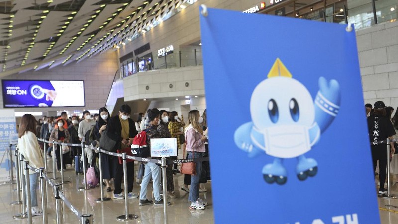 Passengers wearing face masks to help protect against the spread of the coronavirus line up to board planes ahead of the upcoming Chuseok holiday, the Korean version of Thanksgiving Day, at the domestic flight terminal of Gimpo airport in Seoul, South Korea, Wednesday, Sept. 30, 2020. (AP Photo/Ahn Young-joon)