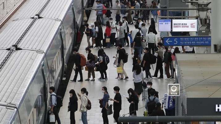 People wearing face masks to help protect against the spread of the coronavirus line up to board a train ahead of the upcoming Chuseok holiday, the Korean version of Thanksgiving Day, at the Seoul Railway Station in Seoul, South Korea, Tuesday, Sept. 29, 2020. (AP Photo/Ahn Young-joon)