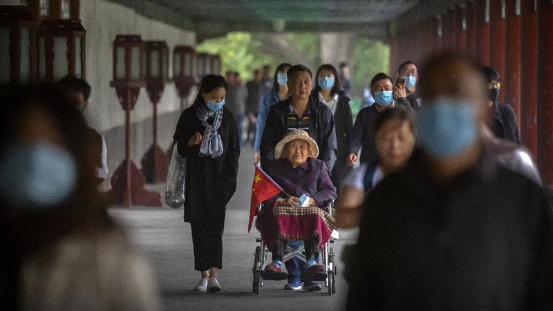 Tourists gather at a waterfront pavilion at the West Lake in Hangzhou in eastern China's Zhejiang Province, Thursday, Oct. 1, 2020. Millions of Chinese tourists usually would use their week-long National Day holidays to travel abroad. This year, travel restrictions due to the coronavirus pandemic mean that some 600 million tourists - about 40% of the population - will travel within China during the holiday that began Thursday, according to Ctrip, China's largest online travel agency. (Chinatopix via AP)