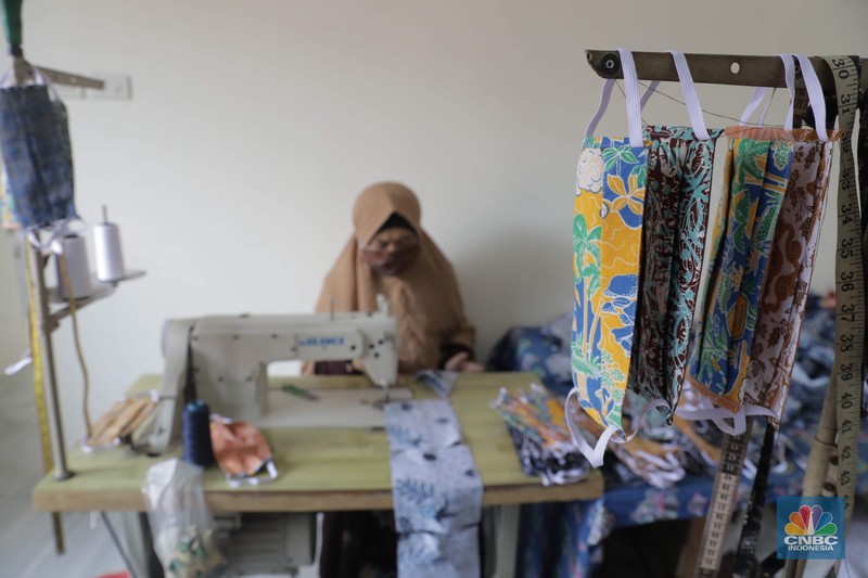 Industri Galeri Batik Khas Bogor Perajin memproduksi masker batik di Sentra Kerajinan Batik Tradisiku, Kota Bogor, Jawa Barat, Jumat (2/10/2020). Pemerintah tanggal 2 Oktober sebagai Hari Batik Nasional. Penetapan tersebut berlandaskan keputusan Perserikatan Bangsa-Bangsa (PBB) yang menetapkan batik menjadi warisan budaya dunia dari Indonesia. Galeri Batik ini merupakan salah satu pusat di mana pengunjung dapat melihat dan memesan batik yang desainnya amat kental dengan nuansa Kota Bogor. Biasanya wisatawan yang hadir ke Bogor bisa melihat dan mengunjungi Galeri Batik ini. Karena adanya aturan PSBB membuat turis asing tidak bisa datang. Ragam desainnya pun rupa-rupa mulai dari motif hujan gerimis, kujang, Kebun Raya, Istana Bogor, dan Batu Tulis. Untuk saat ini perajin sedang garap masker dengan motif batik standar SNI. Seperti diketahui Badan Standardisasi Nasional (BSN) mengeluarkan spesifikasi masker kain ber-SNI yang terbagi menjadi tiga tipe berdasarkan penggunaannya, antara lain tipe A untuk penggunaan umum, tipe B untuk penggunaan filtrasi bakteri, dan tipe C untuk penggunaan filtrasi partikel. (CNBC Indonesia/ Muhammad Sabki