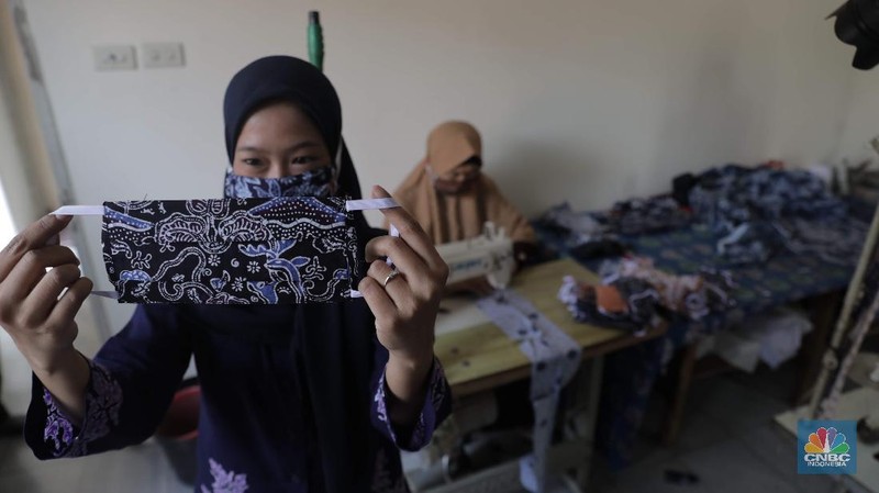 Perajin memproduksi masker batik di Sentra Kerajinan Batik Tradisiku, Kota Bogor, Jawa Barat, Jumat (2/10/2020). Pemerintah tanggal 2 Oktober sebagai Hari Batik Nasional. Penetapan tersebut berlandaskan keputusan Perserikatan Bangsa-Bangsa (PBB) yang menetapkan batik menjadi warisan budaya dunia dari Indonesia. Galeri Batik ini merupakan salah satu pusat di mana pengunjung dapat melihat dan memesan batik yang desainnya amat kental dengan nuansa Kota Bogor. Biasanya wisatawan yang hadir ke Bogor bisa melihat dan mengunjungi Galeri Batik ini. Karena adanya aturan PSBB  membuat turis asing tidak bisa datang. Ragam desainnya pun rupa-rupa mulai dari motif hujan gerimis, kujang, Kebun Raya, Istana Bogor, dan Batu Tulis. Untuk saat ini perajin sedang garap masker dengan motif batik standar SNI. Seperti diketahui Badan Standardisasi Nasional (BSN) mengeluarkan spesifikasi masker kain ber-SNI yang terbagi menjadi tiga tipe berdasarkan penggunaannya, antara lain tipe A untuk penggunaan umum, tipe B untuk penggunaan filtrasi bakteri, dan tipe C untuk penggunaan filtrasi partikel. (CNBC Indonesia/ Muhammad Sabki