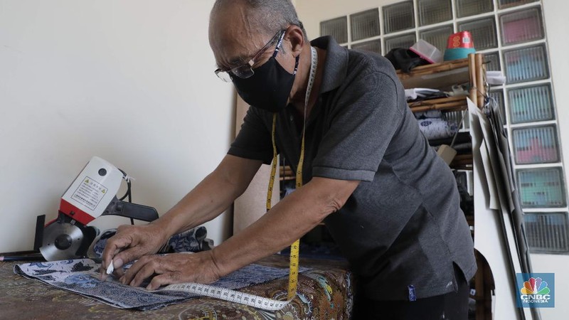 Perajin memproduksi masker batik di Sentra Kerajinan Batik Tradisiku, Kota Bogor, Jawa Barat, Jumat (2/10/2020). Pemerintah tanggal 2 Oktober sebagai Hari Batik Nasional. Penetapan tersebut berlandaskan keputusan Perserikatan Bangsa-Bangsa (PBB) yang menetapkan batik menjadi warisan budaya dunia dari Indonesia. Galeri Batik ini merupakan salah satu pusat di mana pengunjung dapat melihat dan memesan batik yang desainnya amat kental dengan nuansa Kota Bogor. Biasanya wisatawan yang hadir ke Bogor bisa melihat dan mengunjungi Galeri Batik ini. Karena adanya aturan PSBB  membuat turis asing tidak bisa datang. Ragam desainnya pun rupa-rupa mulai dari motif hujan gerimis, kujang, Kebun Raya, Istana Bogor, dan Batu Tulis. Untuk saat ini perajin sedang garap masker dengan motif batik standar SNI. Seperti diketahui Badan Standardisasi Nasional (BSN) mengeluarkan spesifikasi masker kain ber-SNI yang terbagi menjadi tiga tipe berdasarkan penggunaannya, antara lain tipe A untuk penggunaan umum, tipe B untuk penggunaan filtrasi bakteri, dan tipe C untuk penggunaan filtrasi partikel. (CNBC Indonesia/ Muhammad Sabki