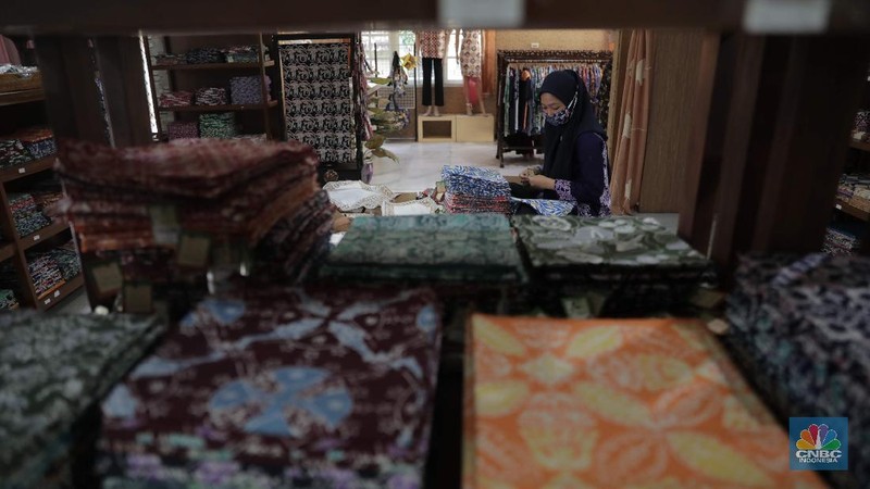 Perajin memproduksi masker batik di Sentra Kerajinan Batik Tradisiku, Kota Bogor, Jawa Barat, Jumat (2/10/2020). Pemerintah tanggal 2 Oktober sebagai Hari Batik Nasional. Penetapan tersebut berlandaskan keputusan Perserikatan Bangsa-Bangsa (PBB) yang menetapkan batik menjadi warisan budaya dunia dari Indonesia. Galeri Batik ini merupakan salah satu pusat di mana pengunjung dapat melihat dan memesan batik yang desainnya amat kental dengan nuansa Kota Bogor. Biasanya wisatawan yang hadir ke Bogor bisa melihat dan mengunjungi Galeri Batik ini. Karena adanya aturan PSBB  membuat turis asing tidak bisa datang. Ragam desainnya pun rupa-rupa mulai dari motif hujan gerimis, kujang, Kebun Raya, Istana Bogor, dan Batu Tulis. Untuk saat ini perajin sedang garap masker dengan motif batik standar SNI. Seperti diketahui Badan Standardisasi Nasional (BSN) mengeluarkan spesifikasi masker kain ber-SNI yang terbagi menjadi tiga tipe berdasarkan penggunaannya, antara lain tipe A untuk penggunaan umum, tipe B untuk penggunaan filtrasi bakteri, dan tipe C untuk penggunaan filtrasi partikel. (CNBC Indonesia/ Muhammad Sabki