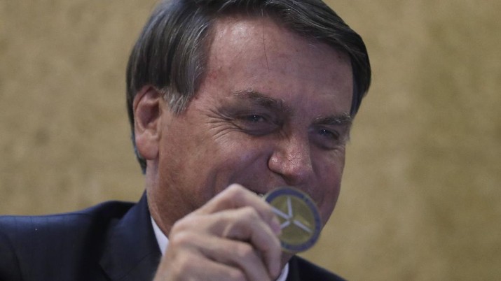 Presiden Brasil, Jair Bolsonaro Brazil's President Jair Bolsonaro shows a Niobium coin, which he received as a gift during the launch of the Mining and Development Program, at the headquarters of the Ministry of Mines and Energy, in Brasilia, Brazil, Monday, Sept. 28, 2020. (AP Photo/Eraldo Peres)