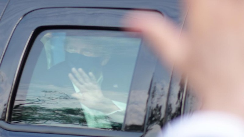 Presiden AS Donald Trump saat melambaikan tangan dari dalam mobil. (AP/Anthony Peltier)