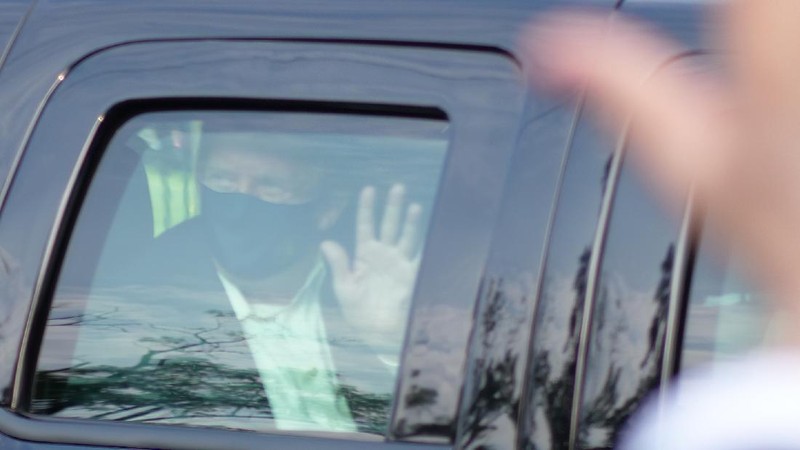 Presiden AS Donald Trump saat melambaikan tangan dari dalam mobil. (AP/Anthony Peltier)
