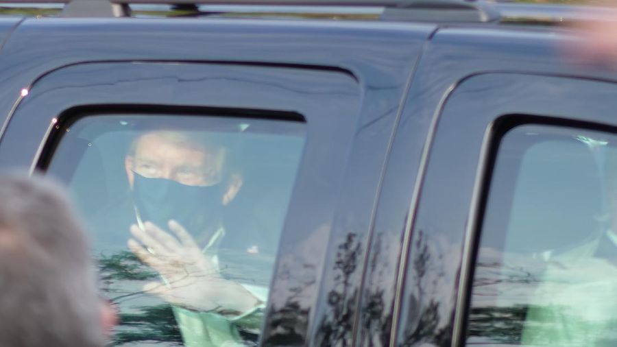 Presiden AS Donald Trump saat melambaikan tangan dari dalam mobil. (AP/Anthony Peltier)