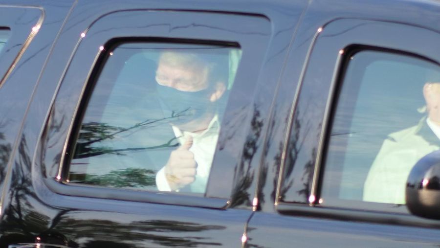 Presiden AS Donald Trump saat melambaikan tangan dari dalam mobil. (AP/Anthony Peltier)