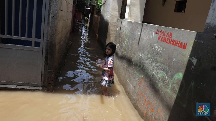Warga beraktifitas saat banjir menggenangi permukiman penduduk di Kebon Pala, Kelurahan Kampung Melayu, Kecamatan Jatinegara, Jakarta Timur. (CNBC Indonesia/Muhammad Sabki)