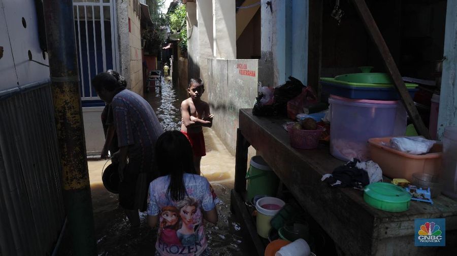 Warga beraktifitas saat banjir menggenangi permukiman penduduk di Kebon Pala, Kelurahan Kampung Melayu, Kecamatan Jatinegara, Jakarta Timur. (CNBC Indonesia/Muhammad Sabki)
