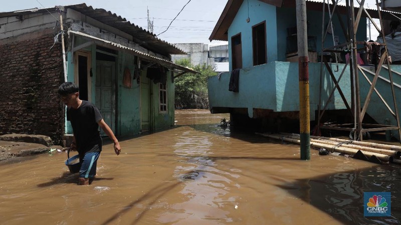 Warga beraktifitas saat banjir menggenangi permukiman penduduk di Kebon Pala, Kelurahan Kampung Melayu, Kecamatan Jatinegara, Jakarta Timur. (CNBC Indonesia/Muhammad Sabki)