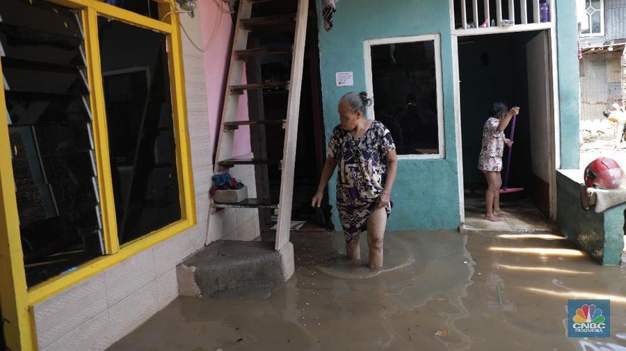 Warga beraktifitas saat banjir menggenangi permukiman penduduk di Kebon Pala, Kelurahan Kampung Melayu, Kecamatan Jatinegara, Jakarta Timur. (CNBC Indonesia/Muhammad Sabki)