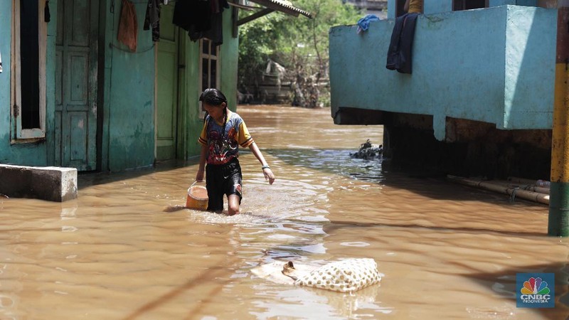Warga beraktifitas saat banjir menggenangi permukiman penduduk di Kebon Pala, Kelurahan Kampung Melayu, Kecamatan Jatinegara, Jakarta Timur. (CNBC Indonesia/Muhammad Sabki)