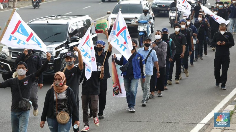 Puluhan buruh berdemo melakukan aksi long march untuk tolak UU Omnibus Law Cipta Kerja di kawasan Cibinong, Bogor. (CNBC Indonesia/Andrean Kristianto)