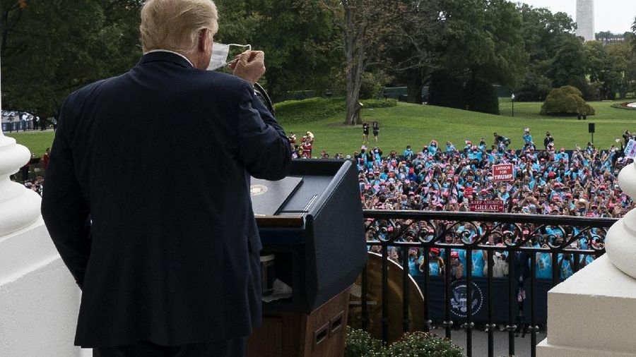 With two bandages on his hand, President Donald Trump gestures while speaking from the Blue Room Balcony of the White House to a crowd of supporters, Saturday, Oct. 10, 2020, in Washington. (AP Photo/Alex Brandon)