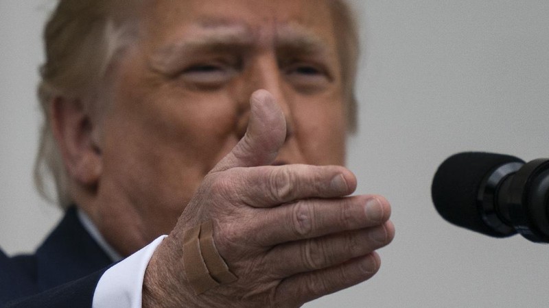With two bandages on his hand, President Donald Trump gestures while speaking from the Blue Room Balcony of the White House to a crowd of supporters, Saturday, Oct. 10, 2020, in Washington. (AP Photo/Alex Brandon)