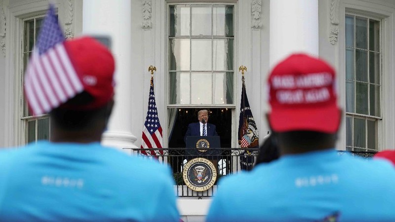 With two bandages on his hand, President Donald Trump gestures while speaking from the Blue Room Balcony of the White House to a crowd of supporters, Saturday, Oct. 10, 2020, in Washington. (AP Photo/Alex Brandon)