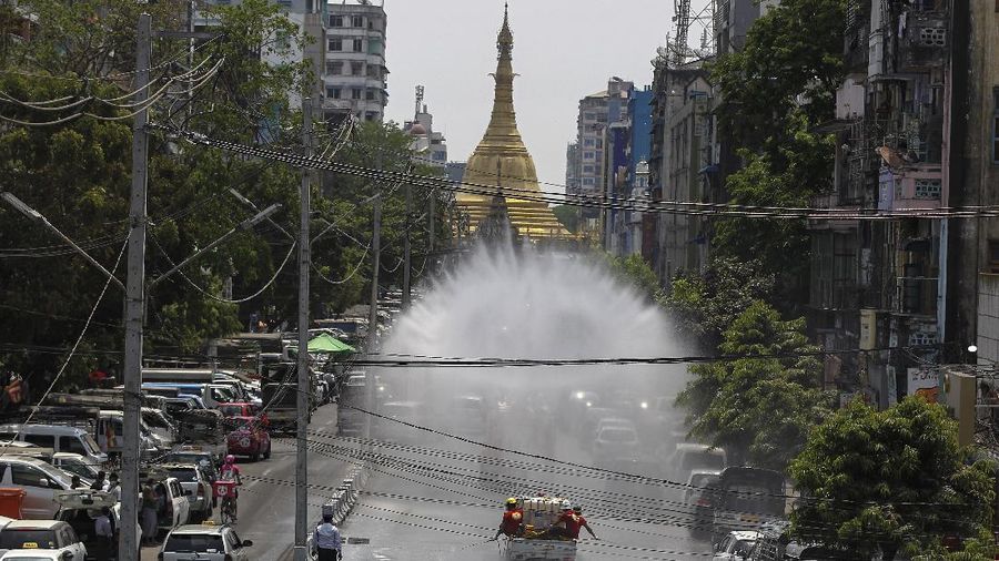 The fire department sprays disinfectant from a fire engine in hopes of curbing the spread of the new coronavirus on a road to Sule Pagoda Tuesday, April 21, 2020, in Yangon, Myanmar. (AP Photo/Thein Zaw)