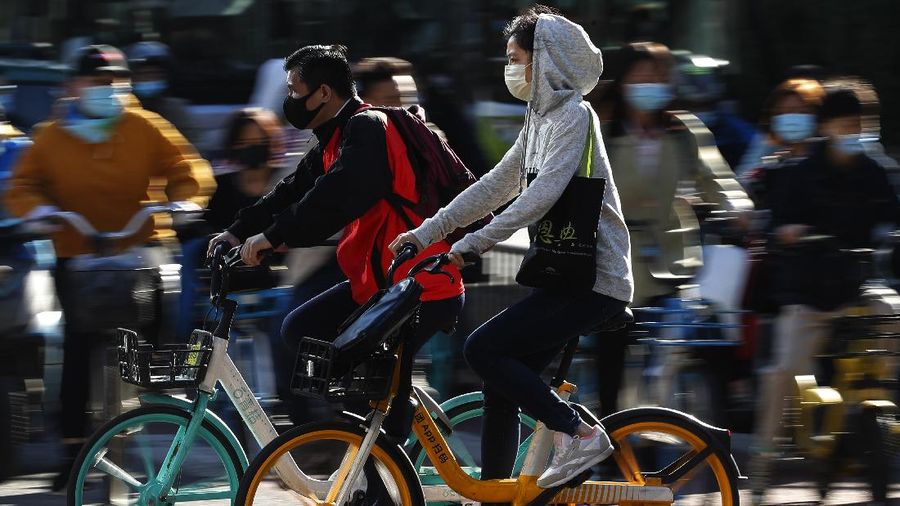 People wearing face masks to help curb the spread of the coronavirus ride bicycle during the morning rush hour in Beijing, Monday, Oct. 12, 2020. Even as China has largely controlled the outbreak, the coronavirus is still surging across the globe with ever rising death toll. (AP Photo/Andy Wong)