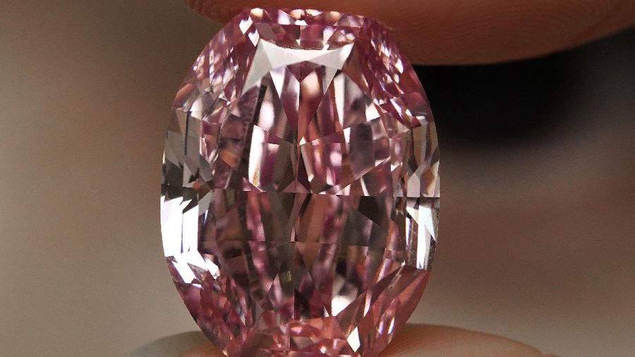 A model displays an ultra-rare 14.83-carat diamond that is one of the largest internally flawless fancy vivid purple-pink gem ever graded by the Gemological Institute of America at a Sotheby's auction room in Hong Kong Monday, Oct. 12, 2020. The diamond will be offered for sale in Geneva on Nov. 11, 2020. (AP Photo/Vincent Yu)