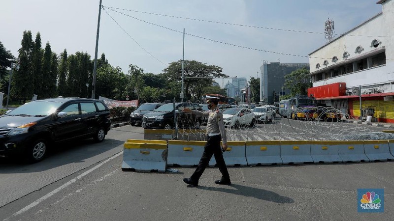 Petugas kepolisan menutup ruas jalan yang menuju ke Istana Presiden dari arah Merdeka Timur, Selasa (13/10/2020).  (CNBC Indonesia/Tri Susilo)