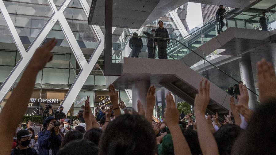Pro-democracy protesters flash three-fingered salute during a protest as they occupied a main road at the central business district in Bangkok, Thailand, Thursday, Oct. 15, 2020. Thailand's government declared a strict new state of emergency for the capital on Thursday, a day after a student-led protest against the country's traditional establishment saw an extraordinary moment in which demonstrators heckled a royal motorcade. (AP Photo/Gemunu Amarasinghe)