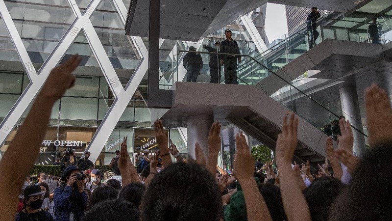 Pro-democracy protesters flash three-fingered salute during a protest as they occupied a main road at the central business district in Bangkok, Thailand, Thursday, Oct. 15, 2020. Thailand's government declared a strict new state of emergency for the capital on Thursday, a day after a student-led protest against the country's traditional establishment saw an extraordinary moment in which demonstrators heckled a royal motorcade. (AP Photo/Gemunu Amarasinghe)