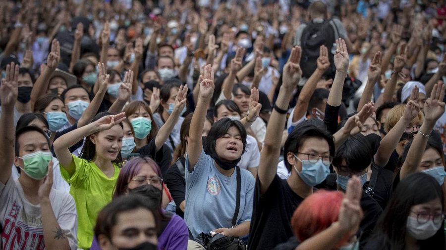 Pro-democracy protesters flash three-fingered salute during a protest as they occupied a main road at the central business district in Bangkok, Thailand, Thursday, Oct. 15, 2020. Thailand's government declared a strict new state of emergency for the capital on Thursday, a day after a student-led protest against the country's traditional establishment saw an extraordinary moment in which demonstrators heckled a royal motorcade. (AP Photo/Gemunu Amarasinghe)
