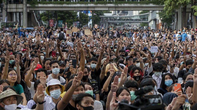 Pro-democracy protesters flash three-fingered salute during a protest as they occupied a main road at the central business district in Bangkok, Thailand, Thursday, Oct. 15, 2020. Thailand's government declared a strict new state of emergency for the capital on Thursday, a day after a student-led protest against the country's traditional establishment saw an extraordinary moment in which demonstrators heckled a royal motorcade. (AP Photo/Gemunu Amarasinghe)