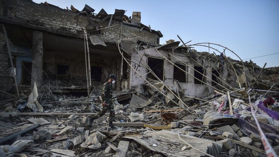 Soldiers and firefighters search for survivors in a residential area that was hit by rocket fire overnight by Armenian forces, early Saturday, Oct. 17, 2020, in Gyanga, Azerbaijan's second largest city, near the border with Armenia. (AP Photo/Aziz Karimov)