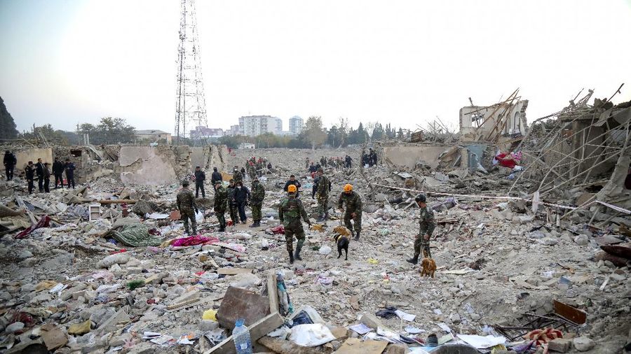 Soldiers and firefighters search for survivors in a residential area that was hit by rocket fire overnight by Armenian forces, early Saturday, Oct. 17, 2020, in Gyanga, Azerbaijan's second largest city, near the border with Armenia. (AP Photo/Aziz Karimov)